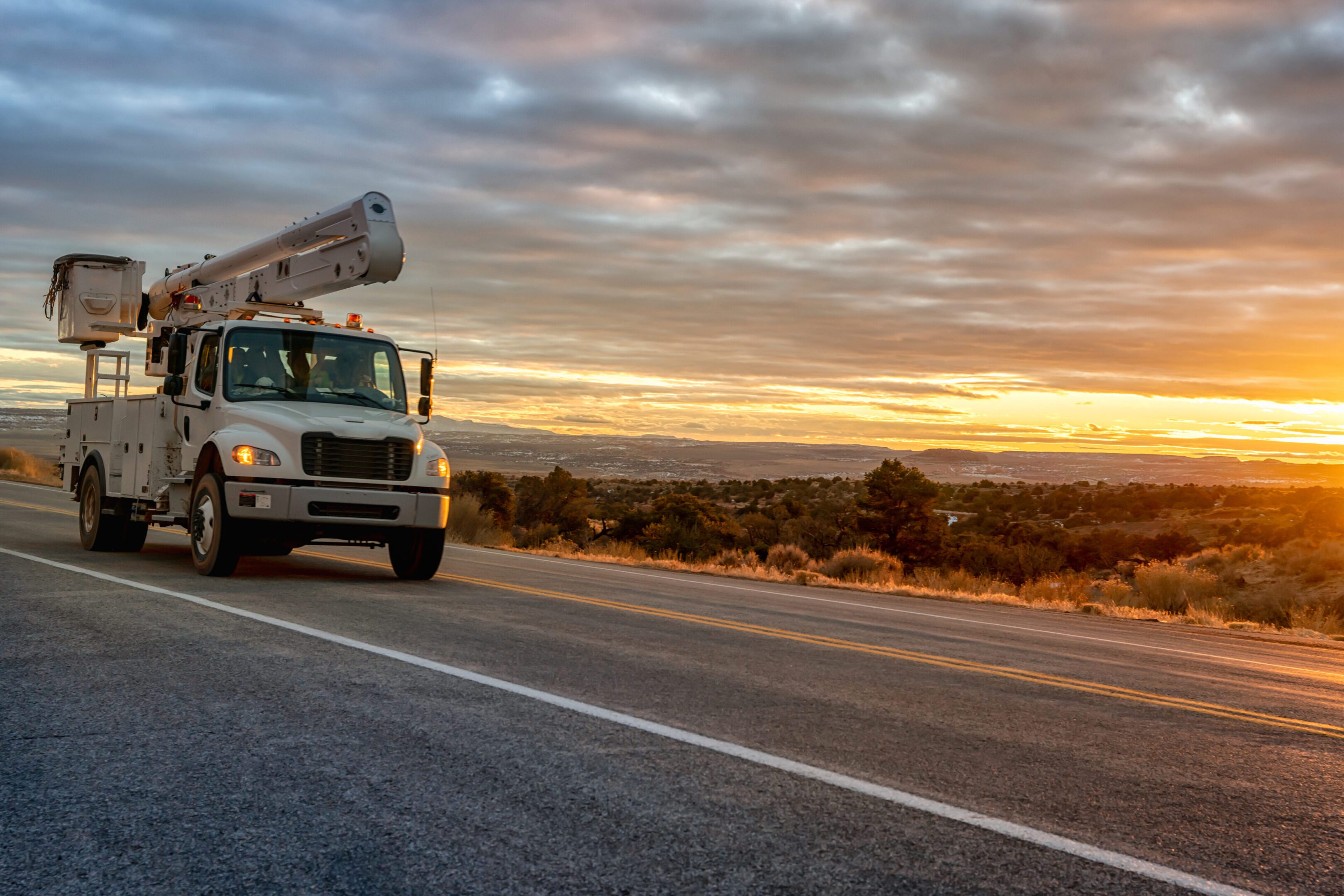 Utility vehicle traveling on highway at dawn