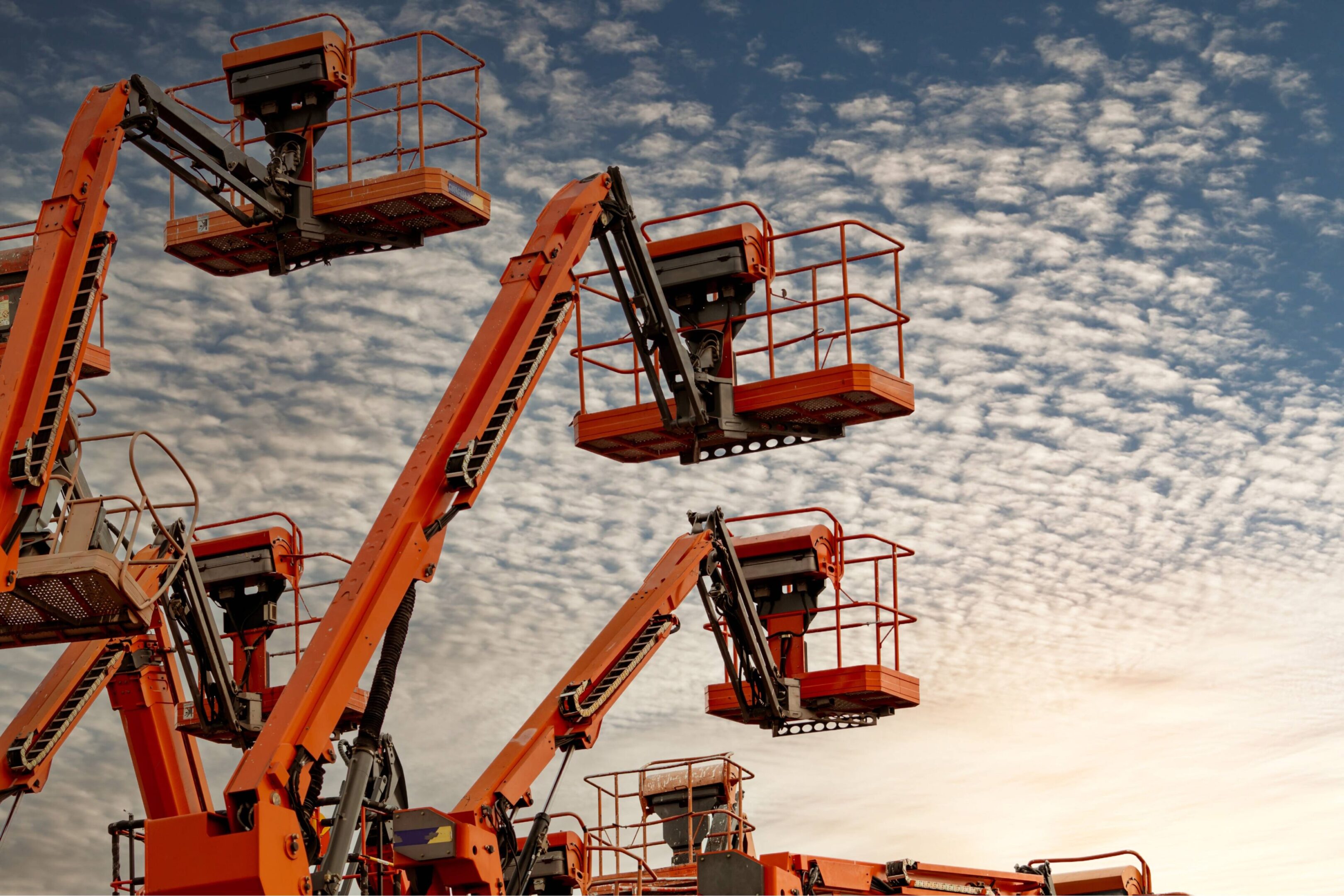 Orange aerial lifts reaching upward